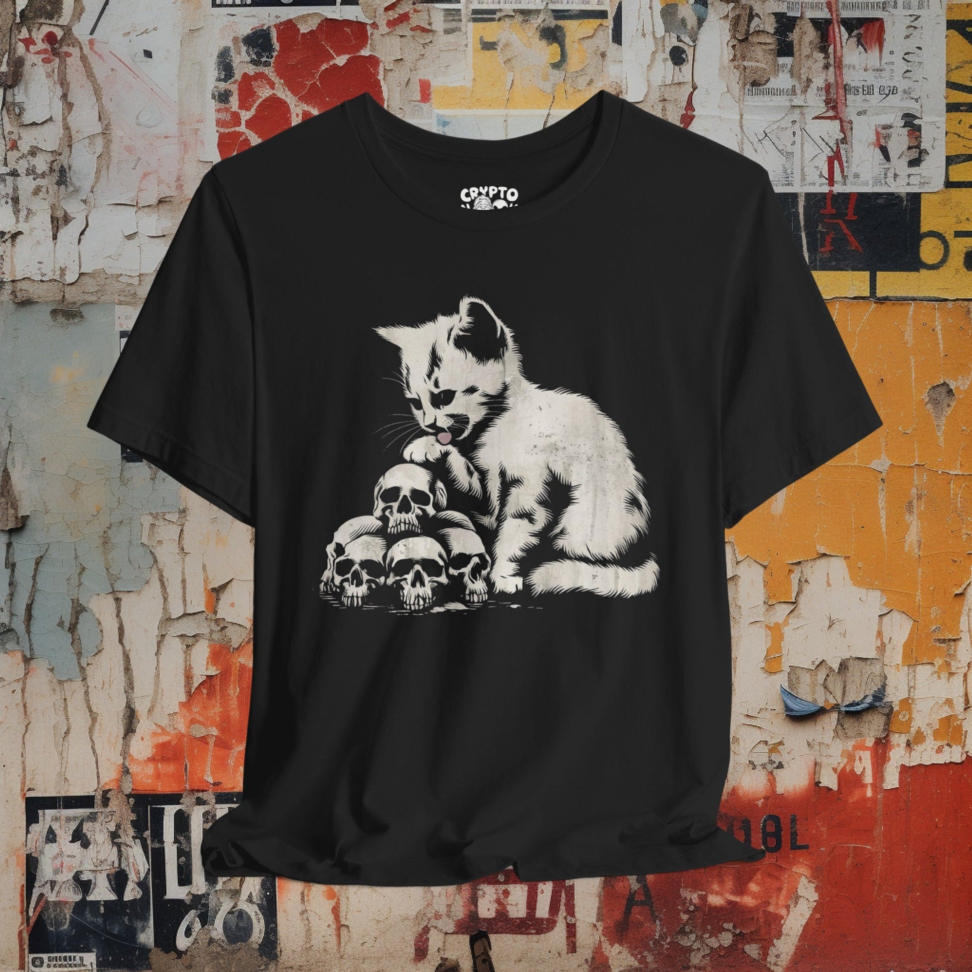 T-Shirt - Cat Licking Paw on Pile of Skulls Dark Humor Shirt | Bella + Canvas Unisex T-shirt from Crypto Zoo Tees